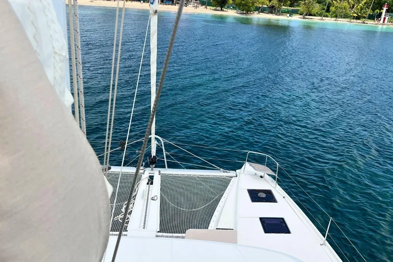 Dignity Yacht Photos Pics Lagoon 50 catamaran sailing near a tropical shoreline, 2021 model.