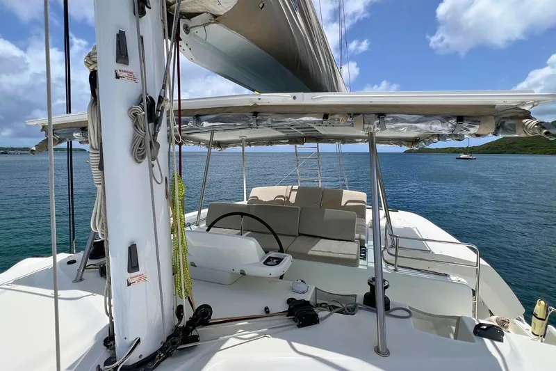 Dignity Yacht Photos Pics 2021 Lagoon 50 catamaran cockpit with seating, steering wheel, and ocean view.