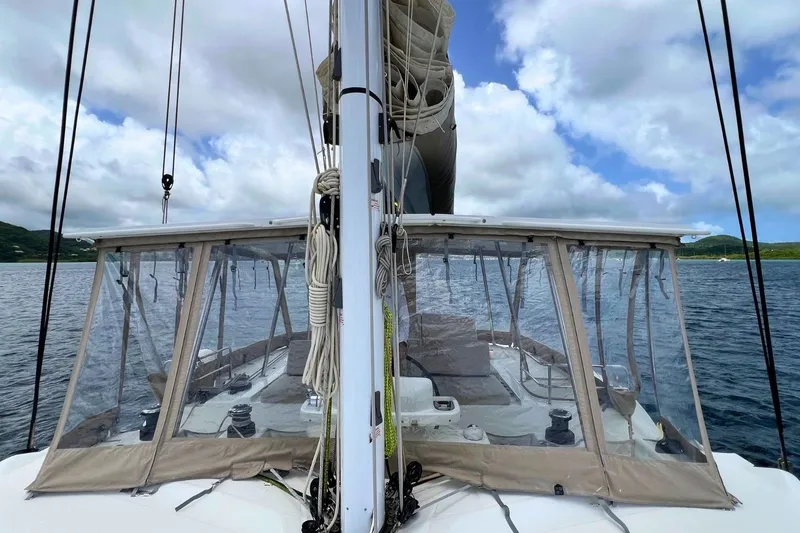 Dignity Yacht Photos Pics 2021 Lagoon 50 catamaran with clear enclosures, sailing on a calm sea under cloudy skies.