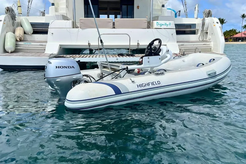 Dignity Yacht Photos Pics Lagoon 50 catamaran with Highfield dinghy and Honda motor in clear blue water, 2021 model.