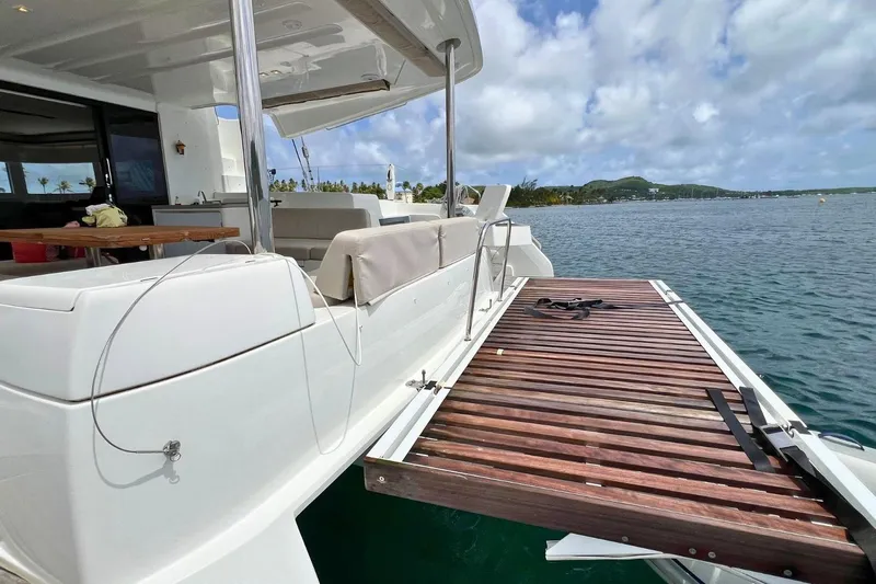 Dignity Yacht Photos Pics Lagoon 50 catamaran 2021 with open deck, wooden platform, and scenic ocean view.