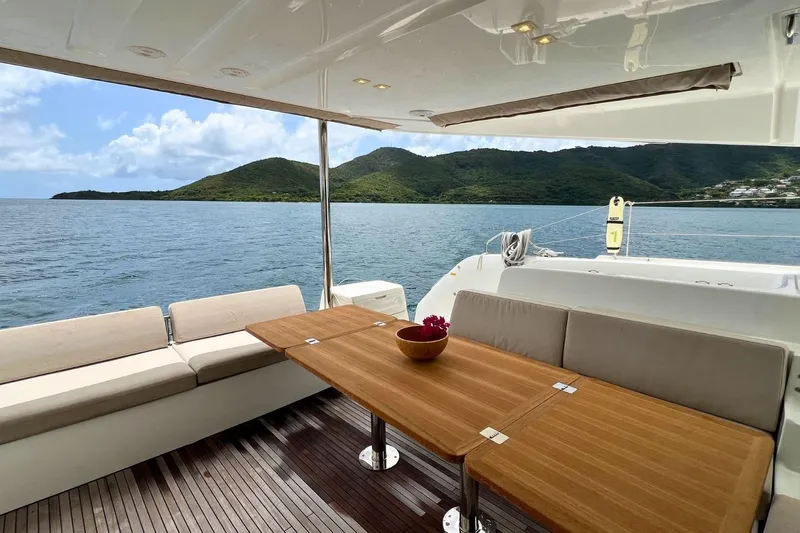 Dignity Yacht Photos Pics Luxurious Lagoon 50 yacht deck with seating, table, and scenic ocean view, 2021 model.
