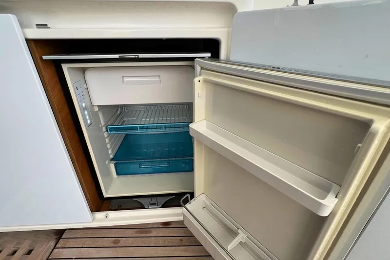 Dignity Yacht Photos Pics Open refrigerator on Lagoon 50 yacht, 2021 model, with empty shelves and door compartments.