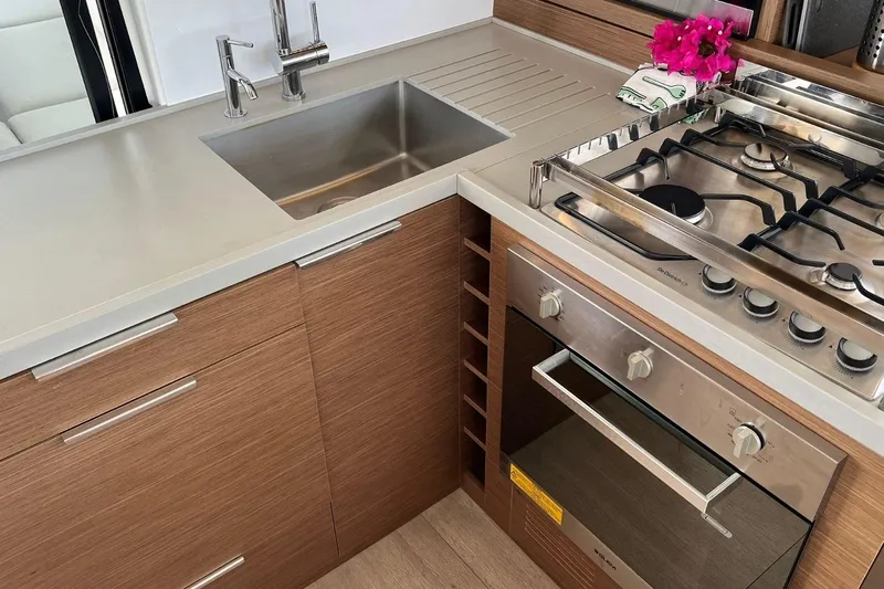 Dignity Yacht Photos Pics Modern kitchen in 2021 Lagoon 50 yacht with stainless steel appliances and wooden cabinetry.