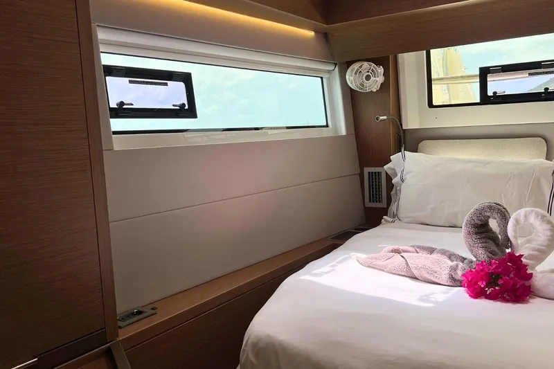 Dignity Yacht Photos Pics Luxurious cabin interior of 2021 Lagoon 50 yacht with elegant bedding and decorative towels.