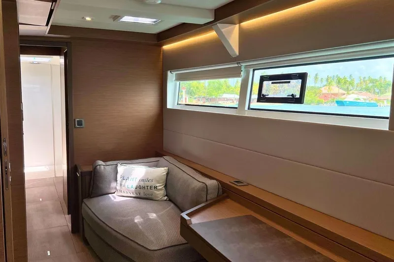 Dignity Yacht Photos Pics Luxurious interior of 2021 Lagoon 50 yacht with cozy seating and scenic window view.