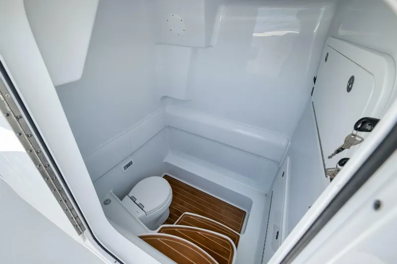  Yacht Photos Pics 2023 Yellowfin 39 Offshore boat interior with compact bathroom and wooden flooring.