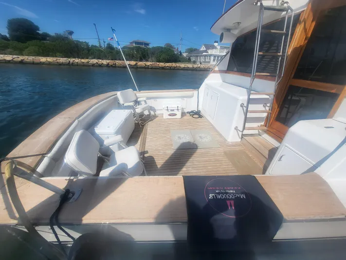 Hailey Girl Yacht Photos Pics 1989 Ocean Yachts 48 boat deck with seating, ladder, and scenic waterfront view.