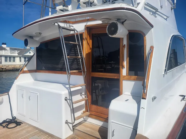 Hailey Girl Yacht Photos Pics 1989 Ocean Yachts 48 boat with wooden accents and ladder, docked by a waterfront house.