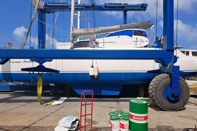 Ocean Mandalay Yacht Photos Pics 2003 Fountaine Pajot Belize 43 catamaran on a boat lift with maintenance supplies nearby.