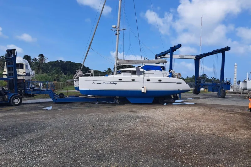 Ocean Mandalay Yacht Photos Pics 2003 Fountaine Pajot Belize 43 catamaran on a boat lift at a marina.