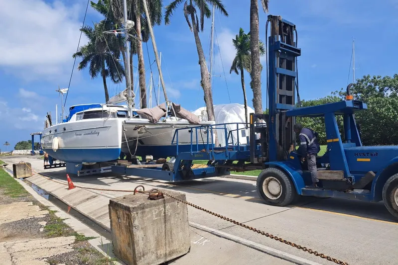 Ocean Mandalay Yacht Photos Pics 2003 Fountaine Pajot Belize 43 catamaran being transported by a blue forklift.
