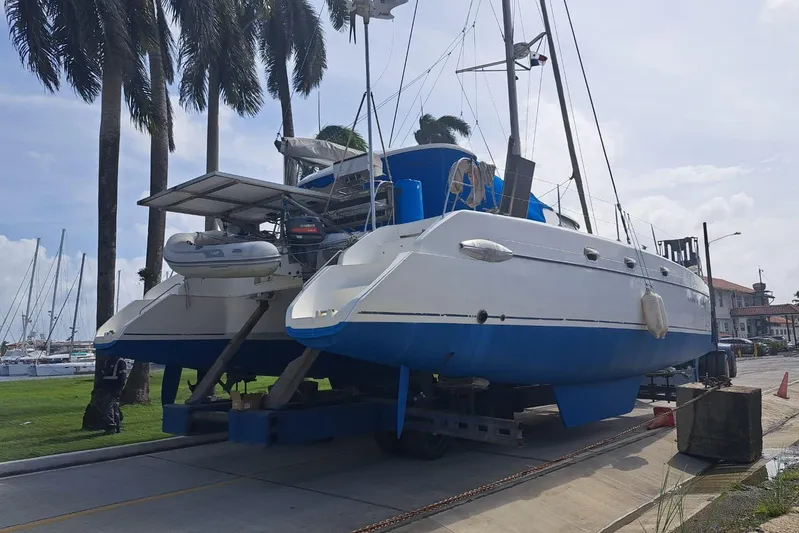 Ocean Mandalay Yacht Photos Pics 2003 Fountaine Pajot Belize 43 catamaran on trailer, surrounded by palm trees and marina.