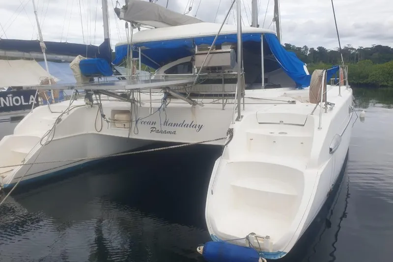 Ocean Mandalay Yacht Photos Pics 2003 Fountaine Pajot Belize 43 catamaran docked with blue canopy and white hull.