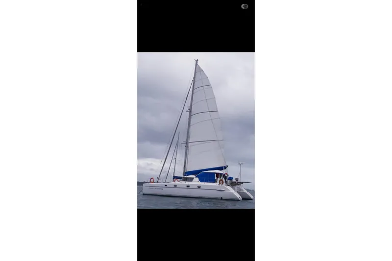 Ocean Mandalay Yacht Photos Pics 2003 Fountaine Pajot Belize 43 catamaran sailing on a cloudy day.