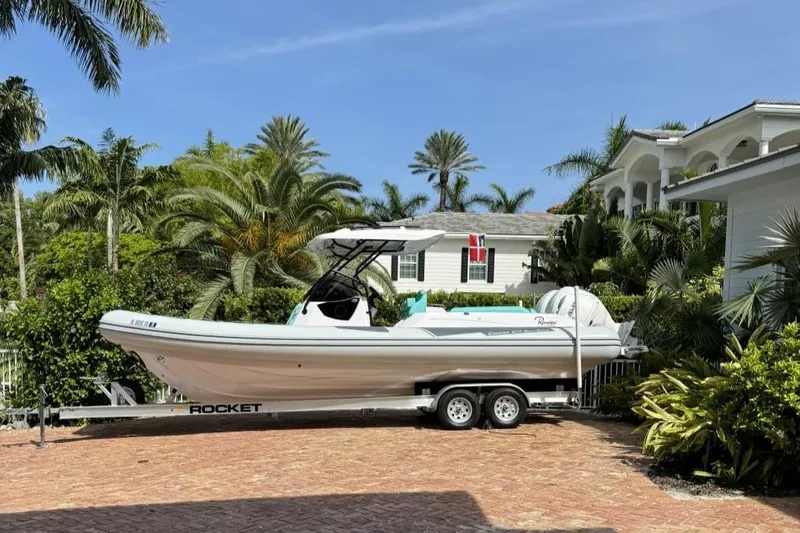  Yacht Photos Pics 2026 Ranieri CAYMAN 27.0 SPORT TOURING boat on trailer, surrounded by tropical greenery.