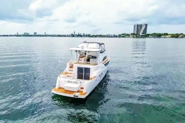 Bella Vita Yacht Photos Pics 2007 Meridian 459 Motoryacht cruising on calm waters near city skyline.