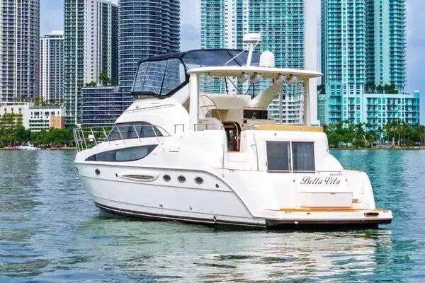 Bella Vita Yacht Photos Pics 2007 Meridian 459 Motoryacht on water with city skyline backdrop.