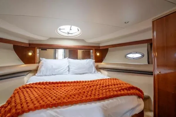 Bella Vita Yacht Photos Pics Luxurious bedroom interior of 2007 Meridian 459 Motoryacht with orange blanket and porthole windows.