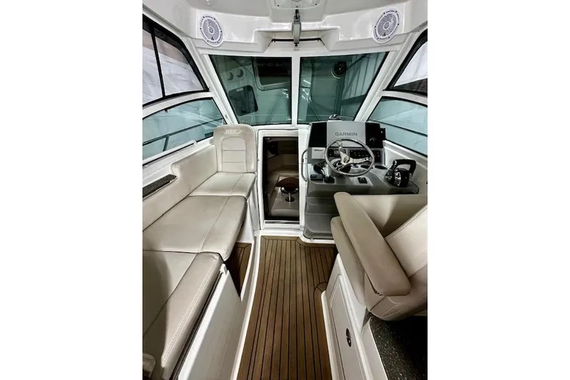  Yacht Photos Pics 2016 Boston Whaler 285 Conquest interior with helm, seating, and wood flooring.