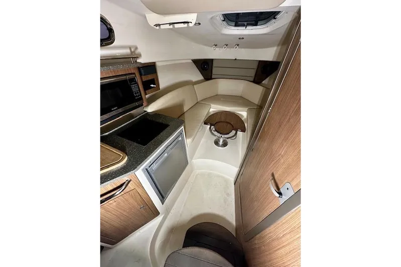  Yacht Photos Pics Interior of 2016 Boston Whaler 285 Conquest boat, featuring kitchenette and seating area.