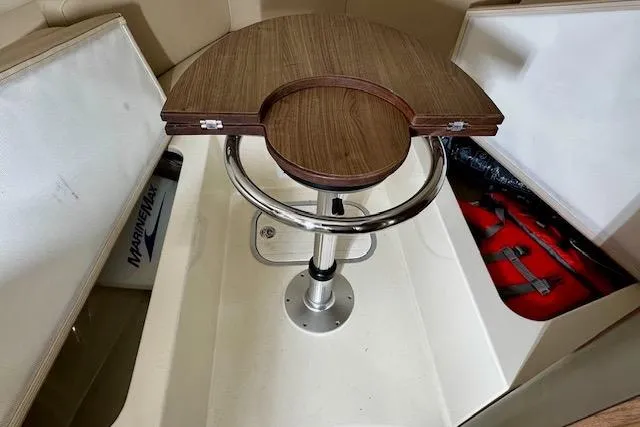  Yacht Photos Pics 2016 Boston Whaler 285 Conquest interior with wooden table and storage compartments.
