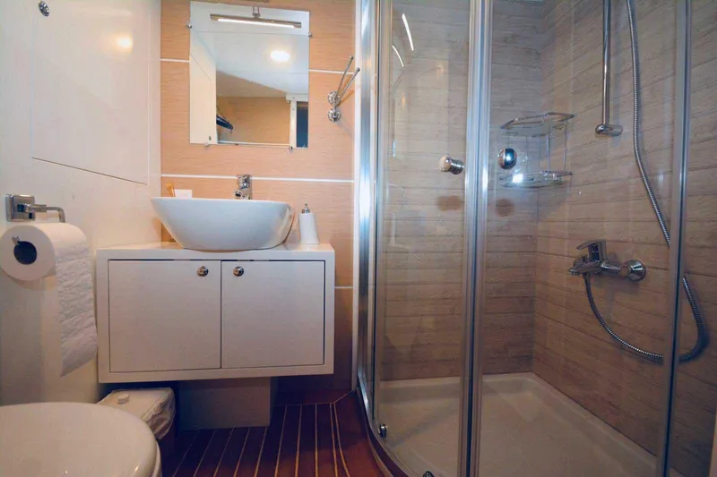  Yacht Photos Pics Modern bathroom with glass shower, vessel sink, and wooden flooring on a 2017 Custom GULET yacht.