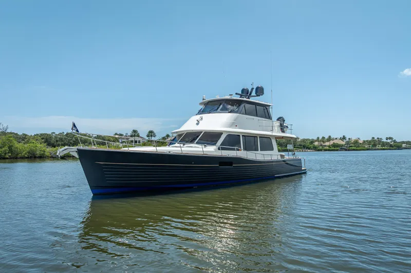 Escape Yacht Photos Pics 2022 Grand Banks GB60 yacht on calm water under clear blue sky.