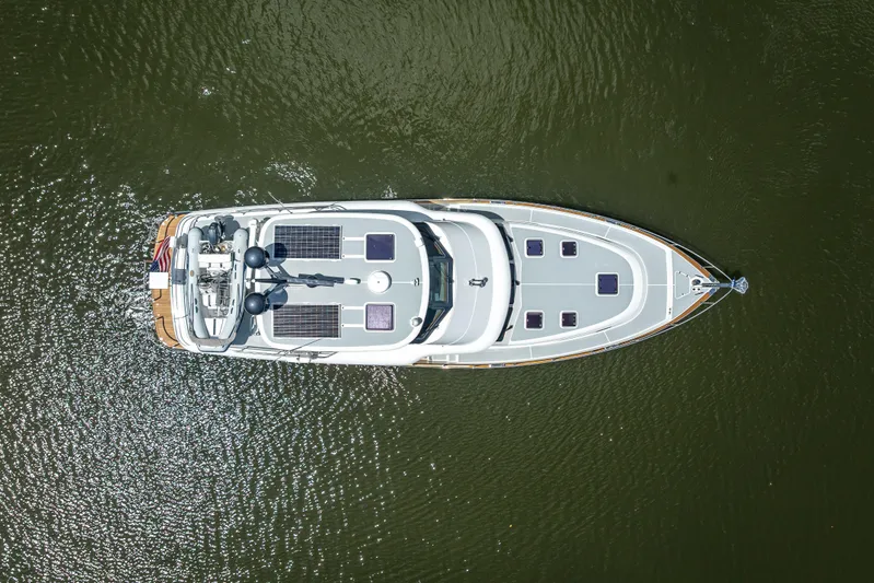 Escape Yacht Photos Pics Overhead view of 2022 Grand Banks GB60 yacht on water, showcasing sleek design and solar panels.