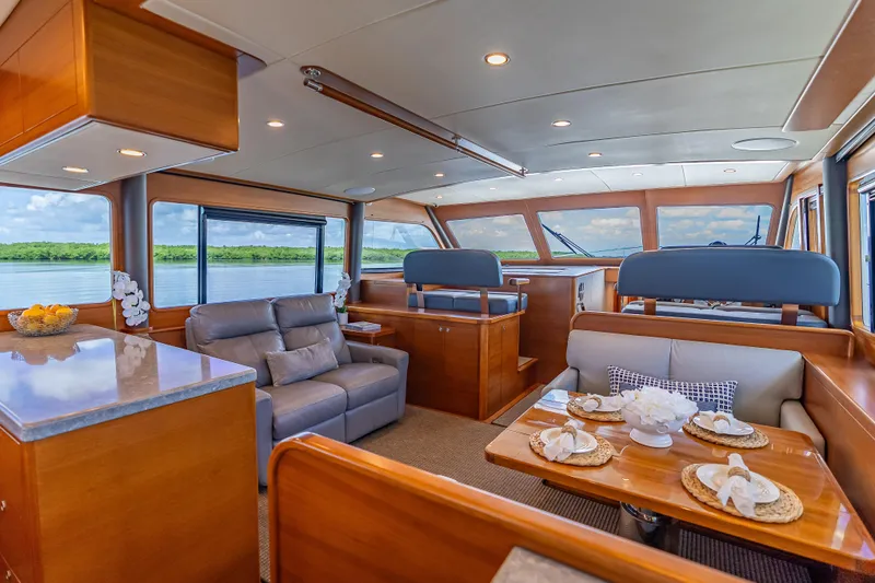 Escape Yacht Photos Pics Luxurious interior of 2022 Grand Banks GB60 Skylounge yacht with elegant seating and dining area.