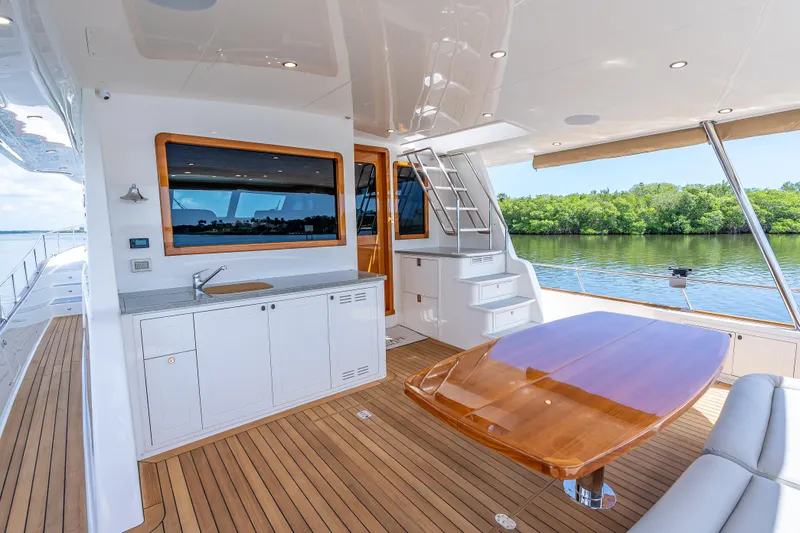 Escape Yacht Photos Pics Luxurious 2022 Grand Banks GB60 Skylounge yacht with elegant teak deck and outdoor dining area.
