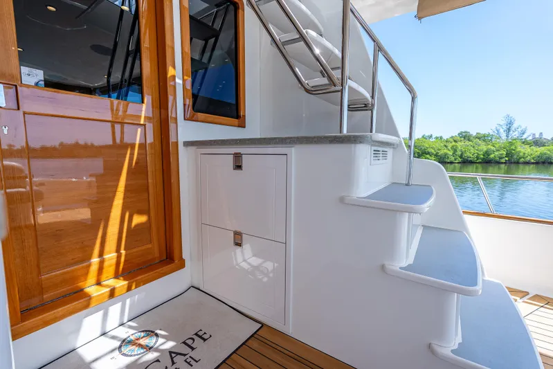 Escape Yacht Photos Pics 2022 Grand Banks GB60 Skylounge yacht with elegant wooden door and sleek staircase.