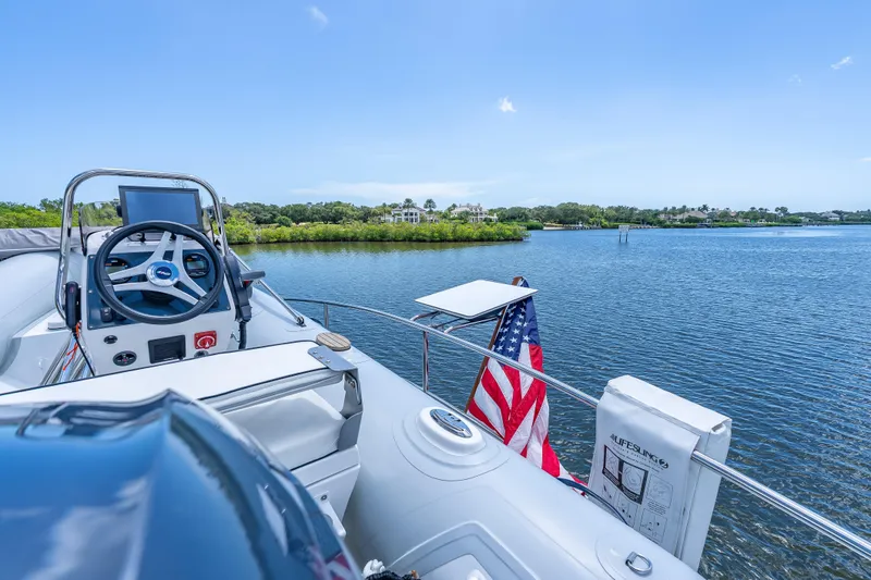 Escape Yacht Photos Pics 2022 Grand Banks GB60 Skylounge yacht with American flag on serene water.