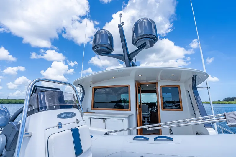 Escape Yacht Photos Pics 2022 Grand Banks GB60 Skylounge yacht with clear blue sky and water backdrop.