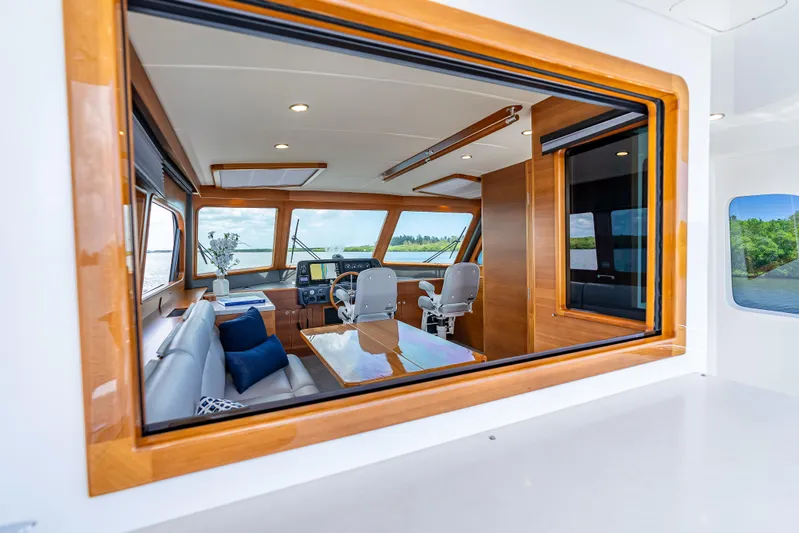 Escape Yacht Photos Pics Interior view of 2022 Grand Banks GB60 Skylounge yacht, featuring luxurious seating and navigation area.