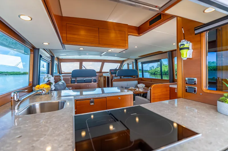 Escape Yacht Photos Pics Luxurious interior of 2022 Grand Banks GB60 Skylounge yacht with modern kitchen and scenic views.