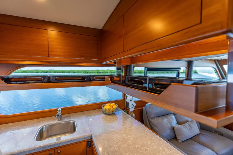 Escape Yacht Photos Pics Luxurious interior of 2022 Grand Banks GB60 Skylounge yacht with elegant wood finish and scenic view.