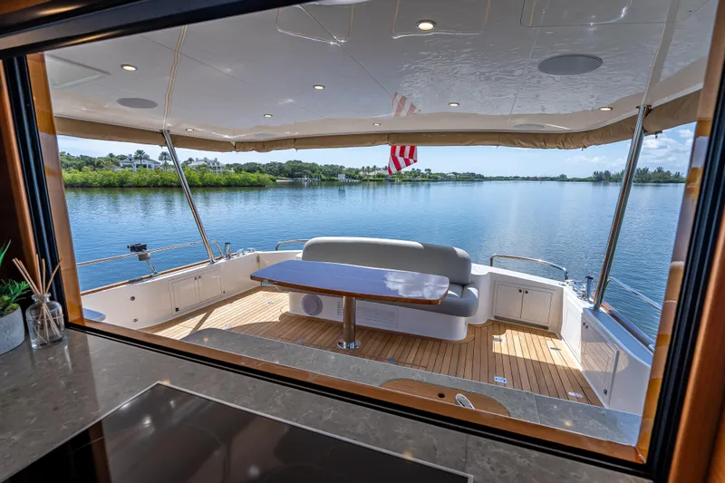 Escape Yacht Photos Pics Luxurious 2022 Grand Banks GB60 Skylounge yacht with elegant deck and scenic water view.