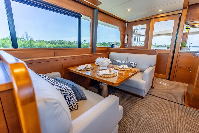 Escape Yacht Photos Pics Luxurious interior of 2022 Grand Banks GB60 Skylounge yacht with elegant dining area.