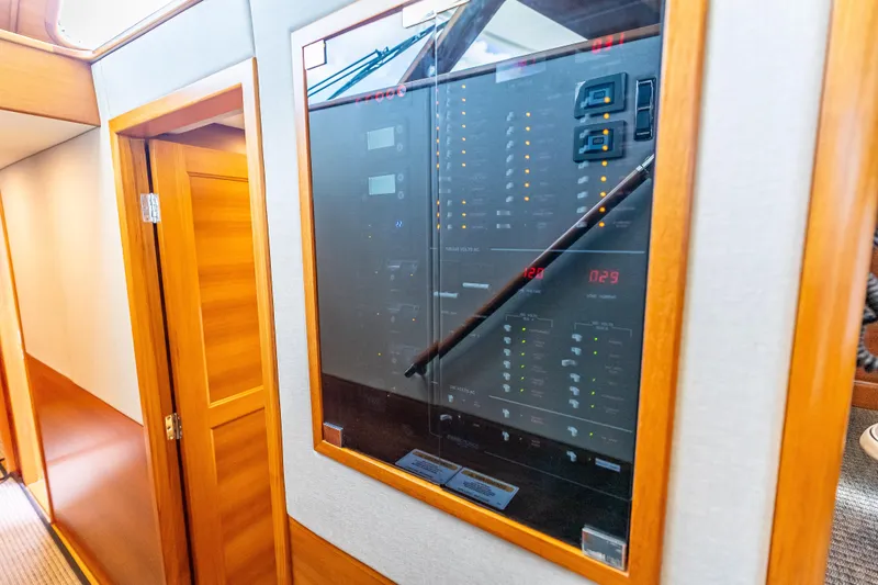 Escape Yacht Photos Pics Electrical panel inside 2022 Grand Banks GB60 Skylounge yacht, featuring wooden interior design.