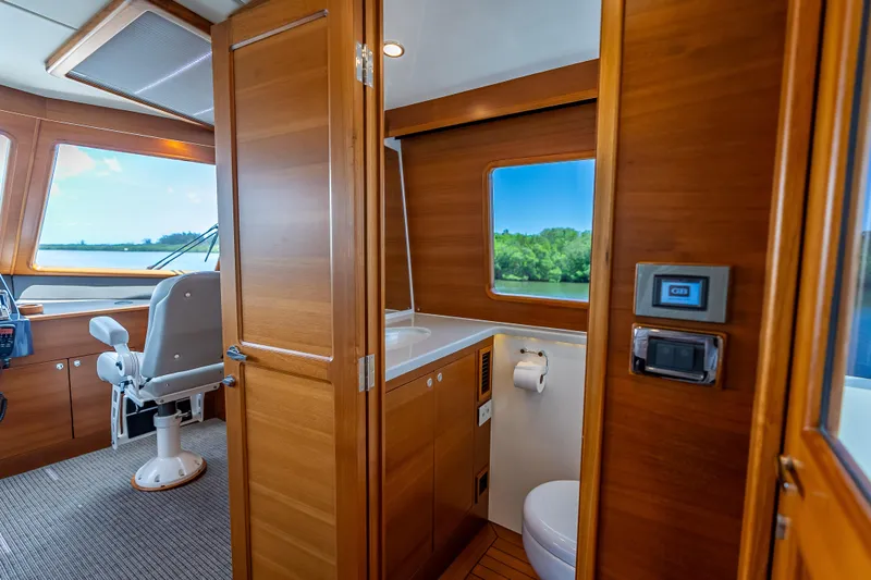 Escape Yacht Photos Pics Luxurious 2022 Grand Banks GB60 Skylounge interior with helm and bathroom.