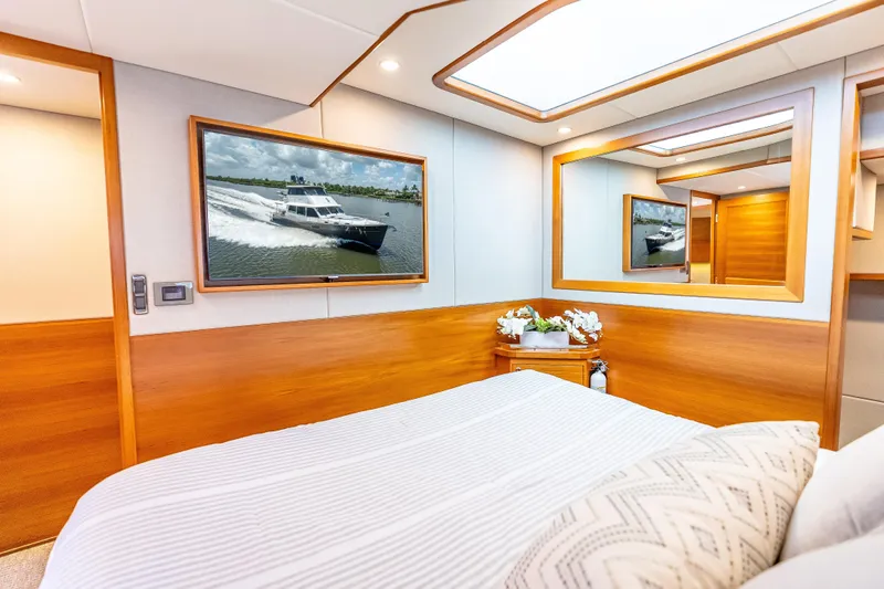 Escape Yacht Photos Pics Luxurious bedroom interior of 2022 Grand Banks GB60 Skylounge yacht with elegant wood finishes.