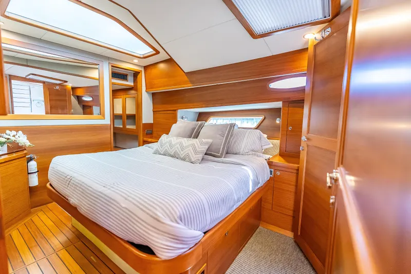 Escape Yacht Photos Pics Luxurious cabin interior of 2022 Grand Banks GB60 Skylounge yacht with elegant wood finish.