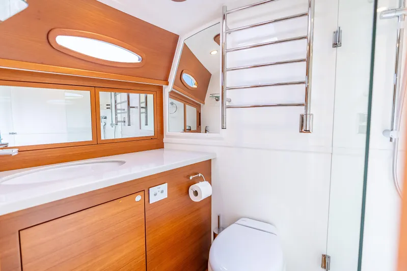 Escape Yacht Photos Pics Luxurious bathroom in 2022 Grand Banks GB60 Skylounge yacht with modern fixtures and wooden accents.