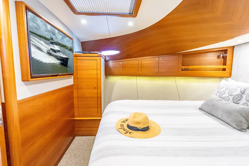 Escape Yacht Photos Pics Luxurious 2022 Grand Banks GB60 Skylounge bedroom with wood accents and modern amenities.