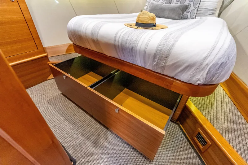 Escape Yacht Photos Pics Under-bed storage in 2022 Grand Banks GB60 Skylounge yacht cabin, featuring a stylish hat.