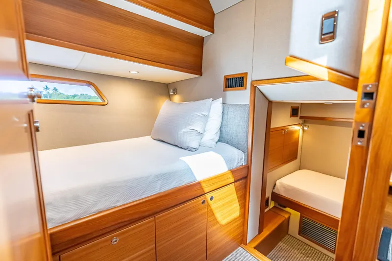 Escape Yacht Photos Pics 2022 Grand Banks GB60 Skylounge cabin with wooden interior and cozy bedding.