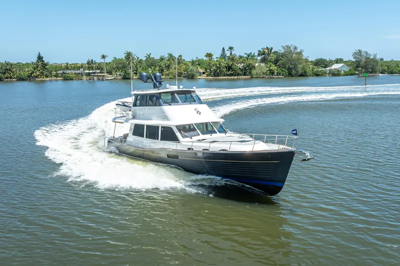 Escape Yacht Photos Pics 2022 Grand Banks GB60 Skylounge yacht cruising on a scenic waterway.