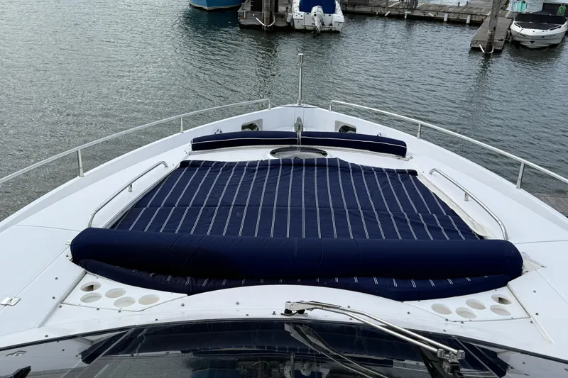  Yacht Photos Pics Sunseeker 75 Yacht 2005 bow with blue-striped sunbed, docked at marina.