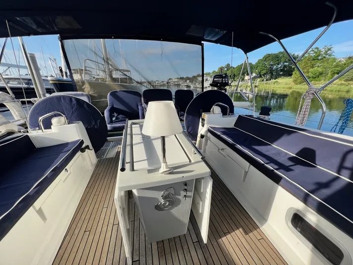 Serendipity Yacht Photos Pics 2013 Beneteau Oceanis 45 yacht cockpit with seating and table, docked by the water.